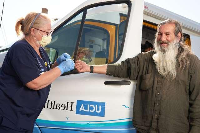 Man checked by nurse next to care van